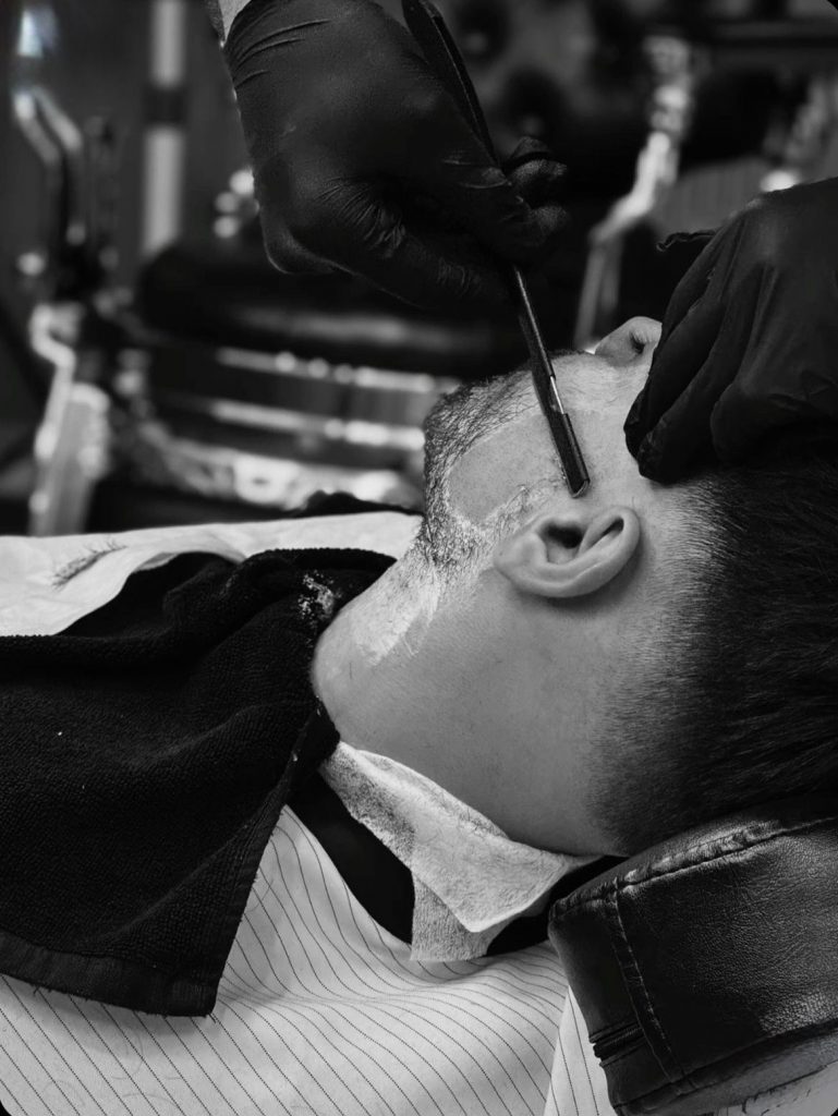 barbero cortando la barba en un curso de barberia completo en Barcelona